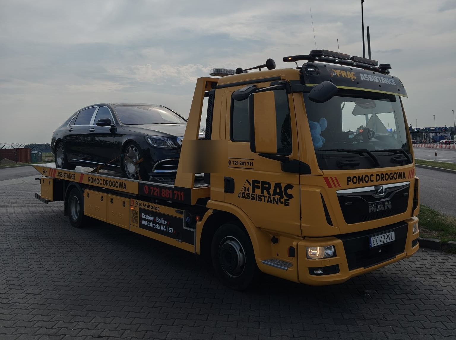 Laweta Frąc Assistance z Mercedesem klasy S na parkingu przy lotnisku Kraków-Balice